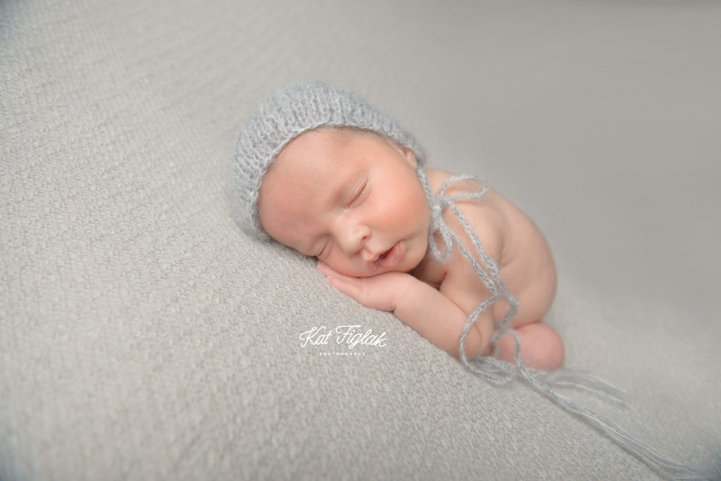 sleeping baby boy with gray bonnet