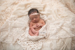 newborn baby girl cuddled in soft layers