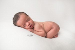 baby girl posed on white fabric