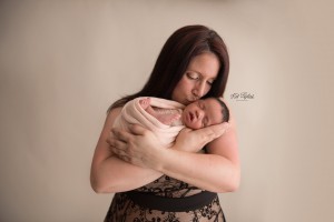 mom kissing newborn baby girl