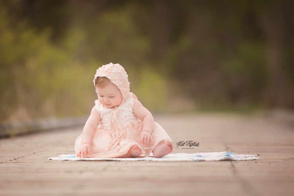 Baby girl in peach dress and bonnet