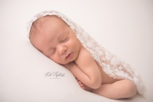 baby girl sleeping covered in white lace