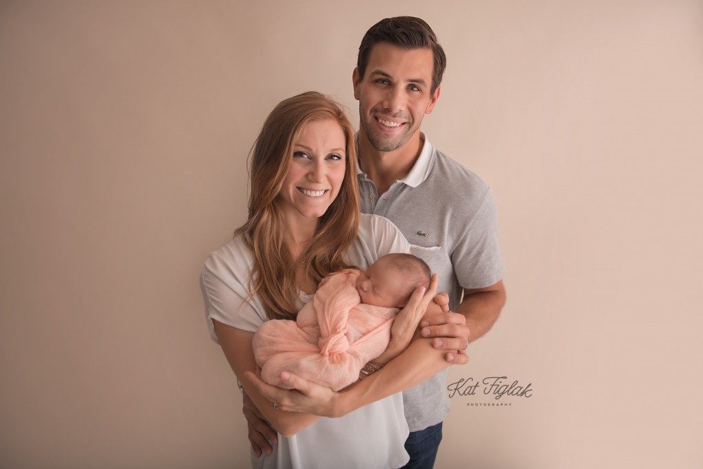 Family of 3 parents holding 8 day old baby girl