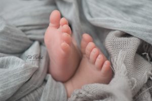 newborn baby toes wrapped in gray knit wrap