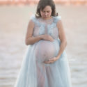 Pregnant mom with twins in blue dress by lake