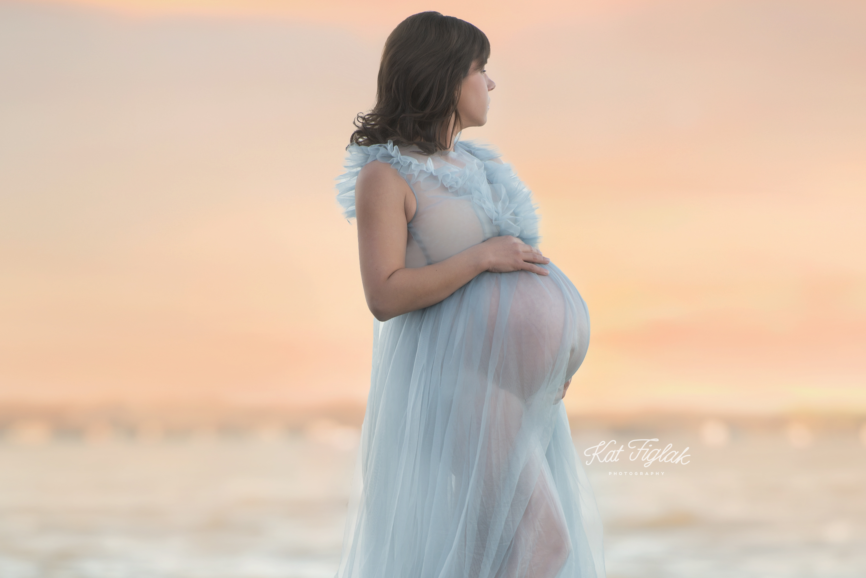 Pregnant mom with twins in blue dress with lake sunset