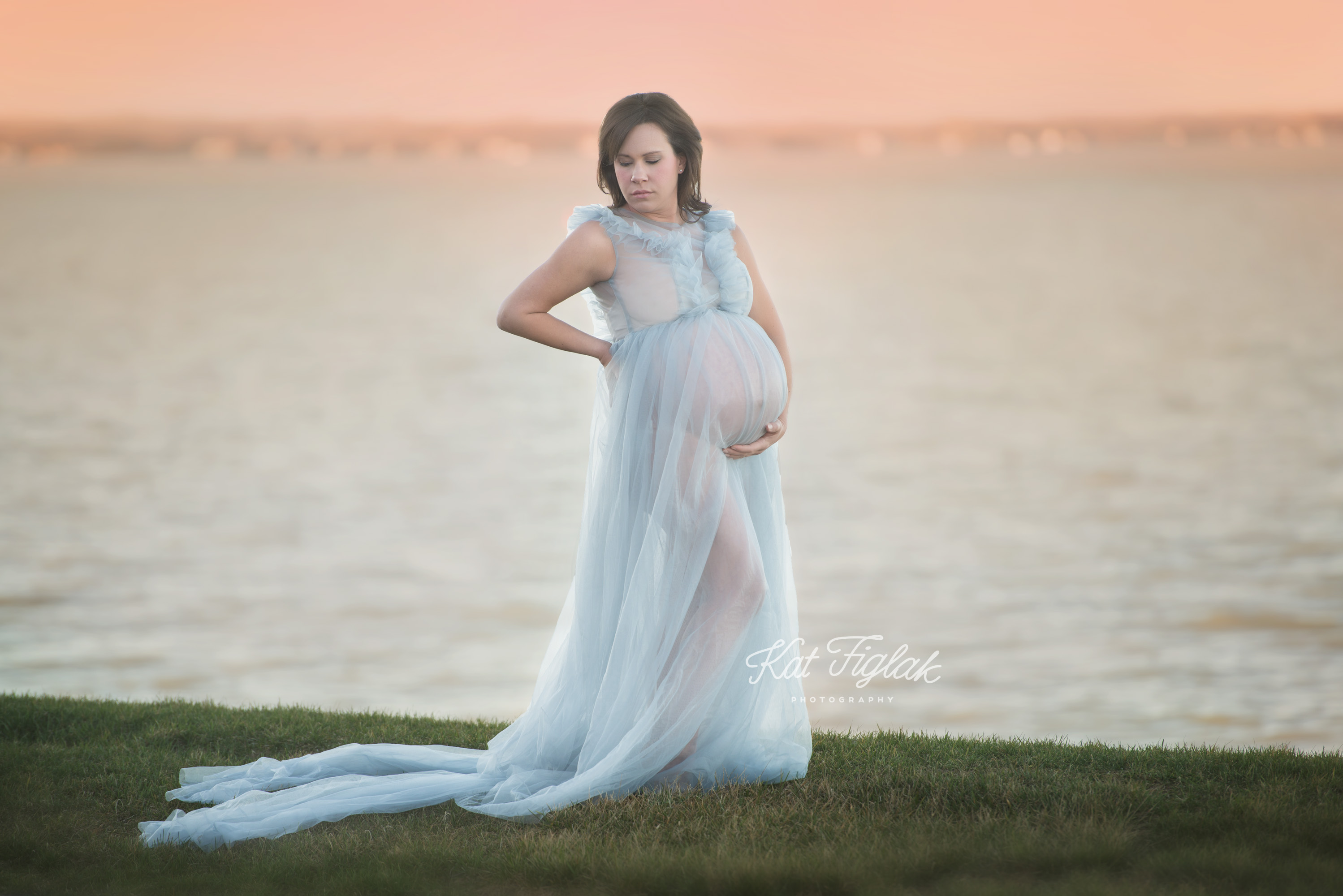 Pregnant mom with twins wearing blue dress in front of lake
