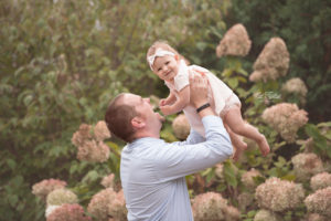 Dad lifting his one year old baby girl in the air