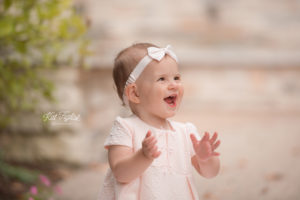 one year old baby girl smiling and clapping