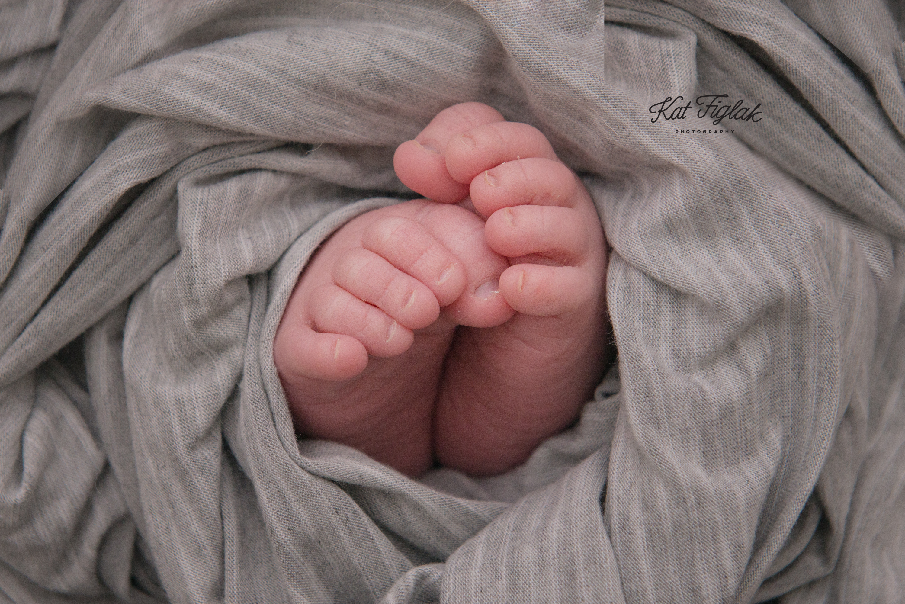 newborn baby toes wrapped in gray fabric