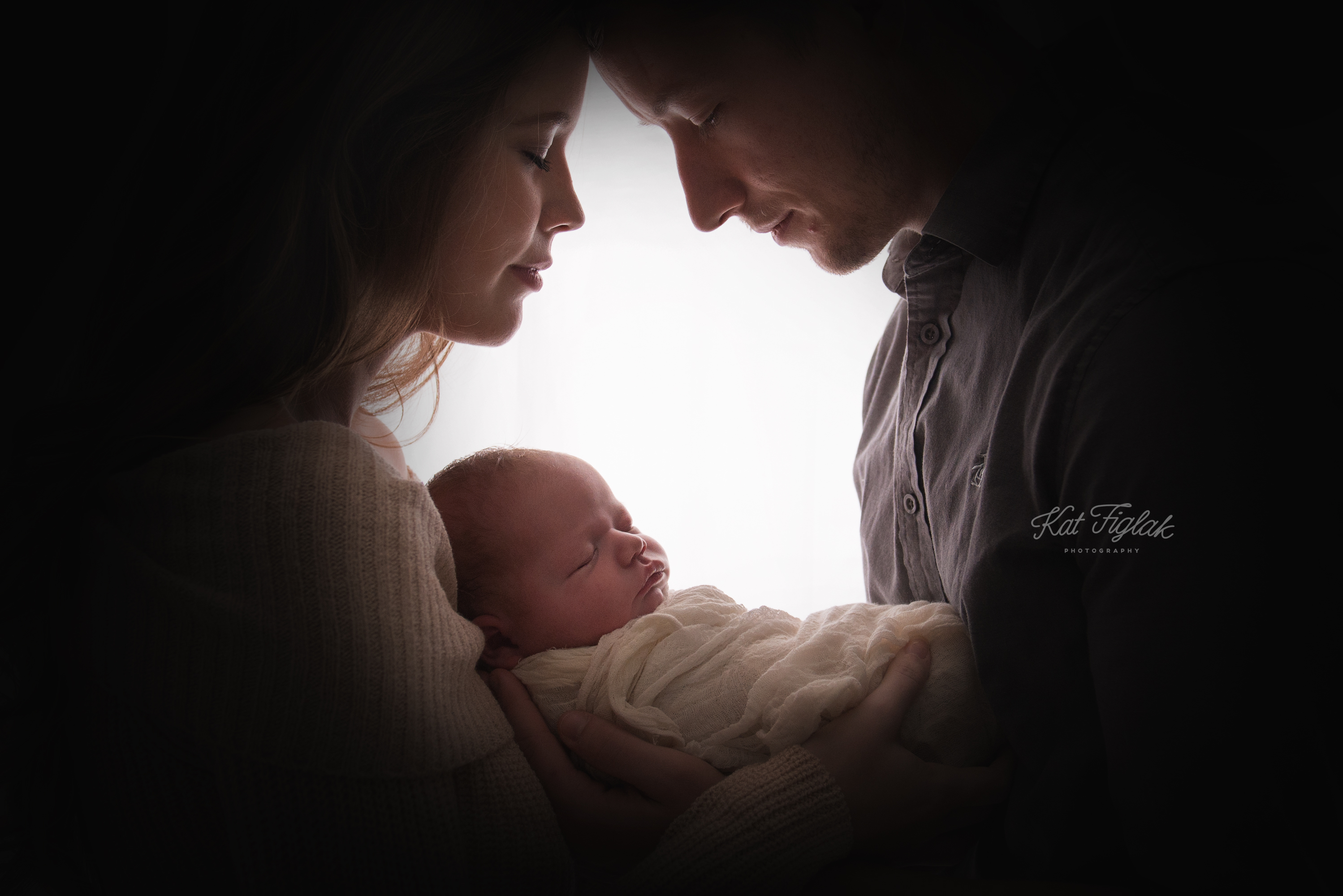 couple holding newborn son silhouette shot of faces
