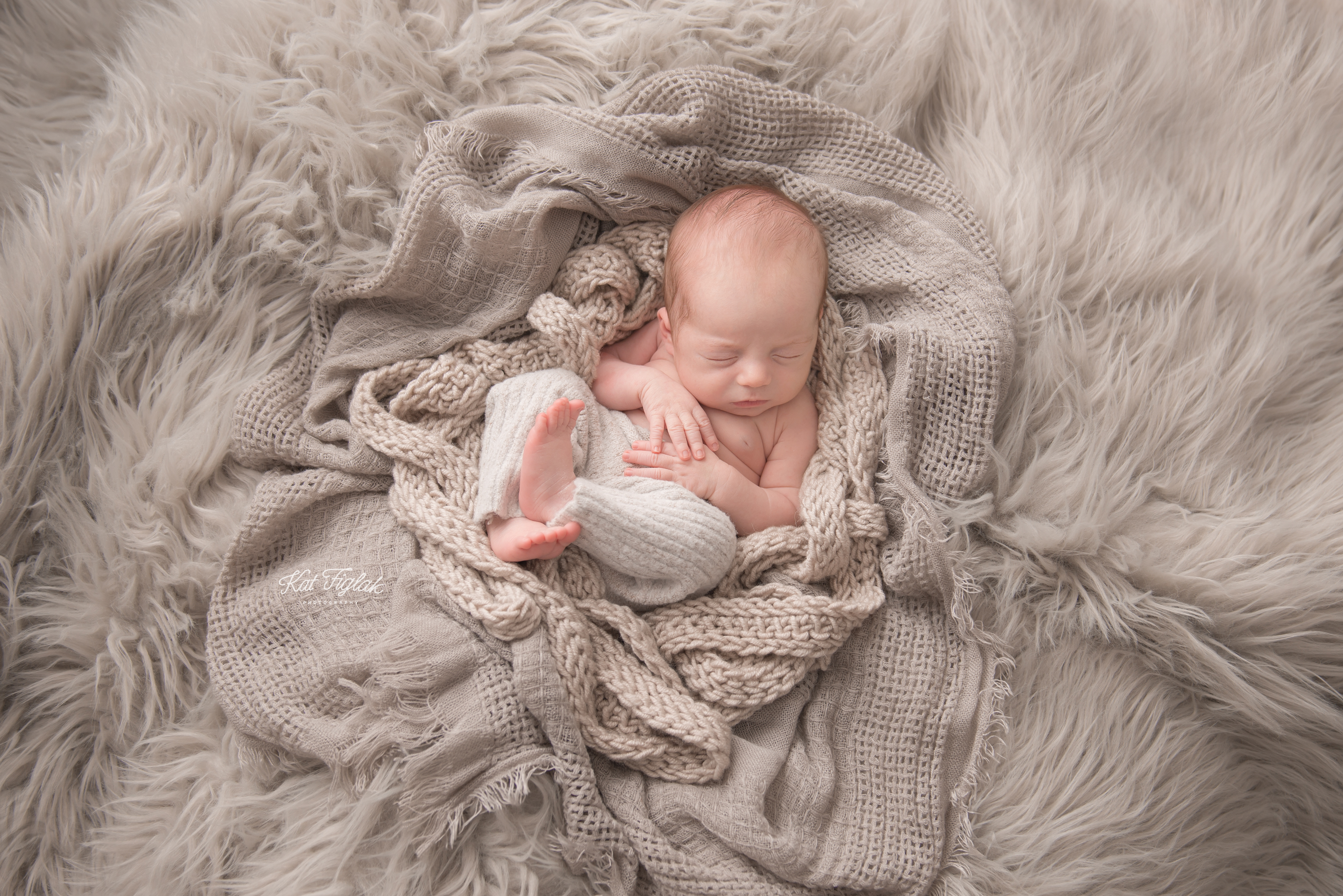 baby boy sleeping in layers of gray fabric