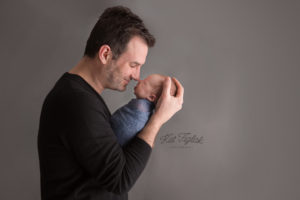 dad holding newborn son with their noses touching