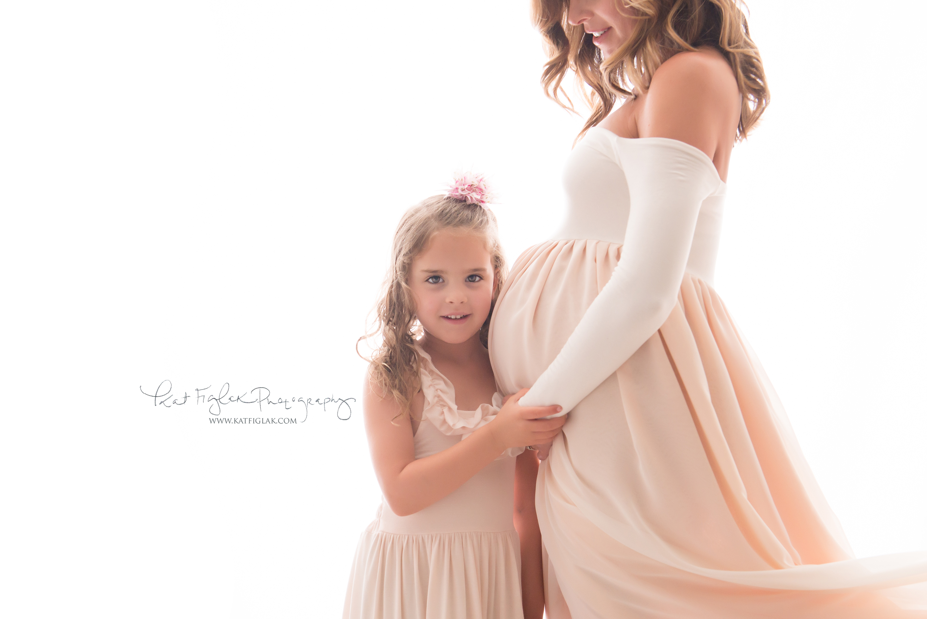 Pregnant mom and daughter in pink dresses