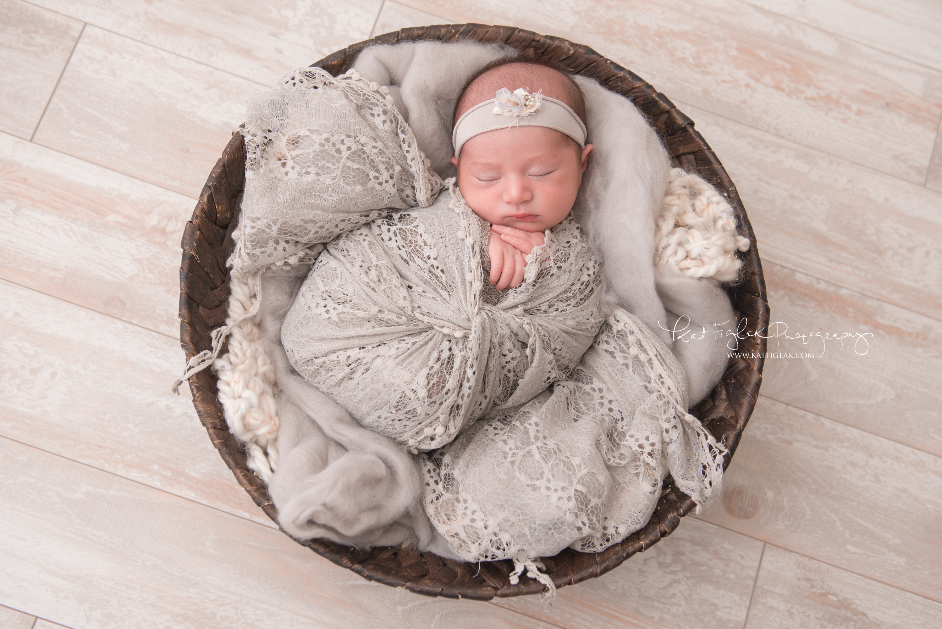 baby swaddled in gray lace wrap in basket
