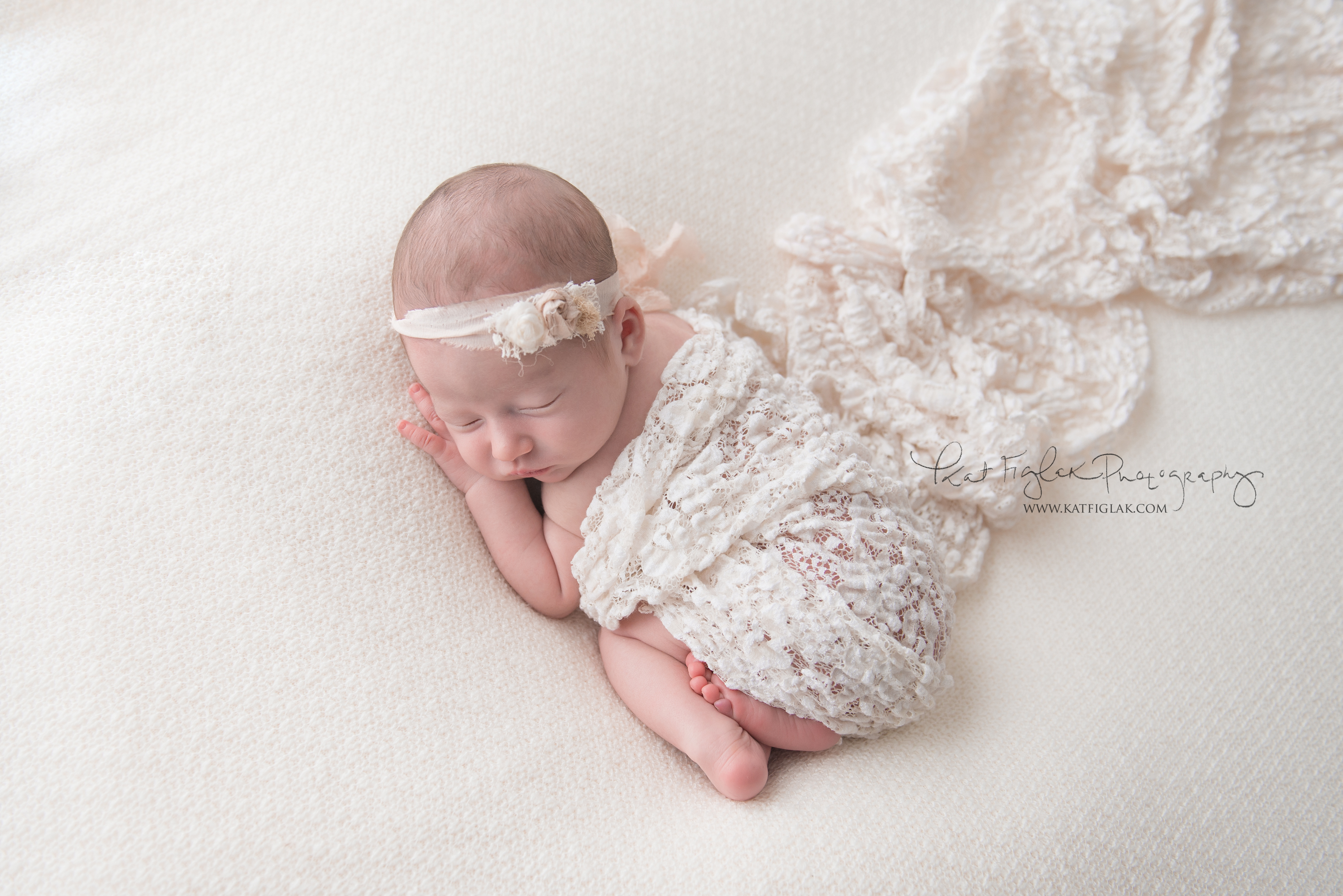 newborn baby girl sleeping draped in white lace