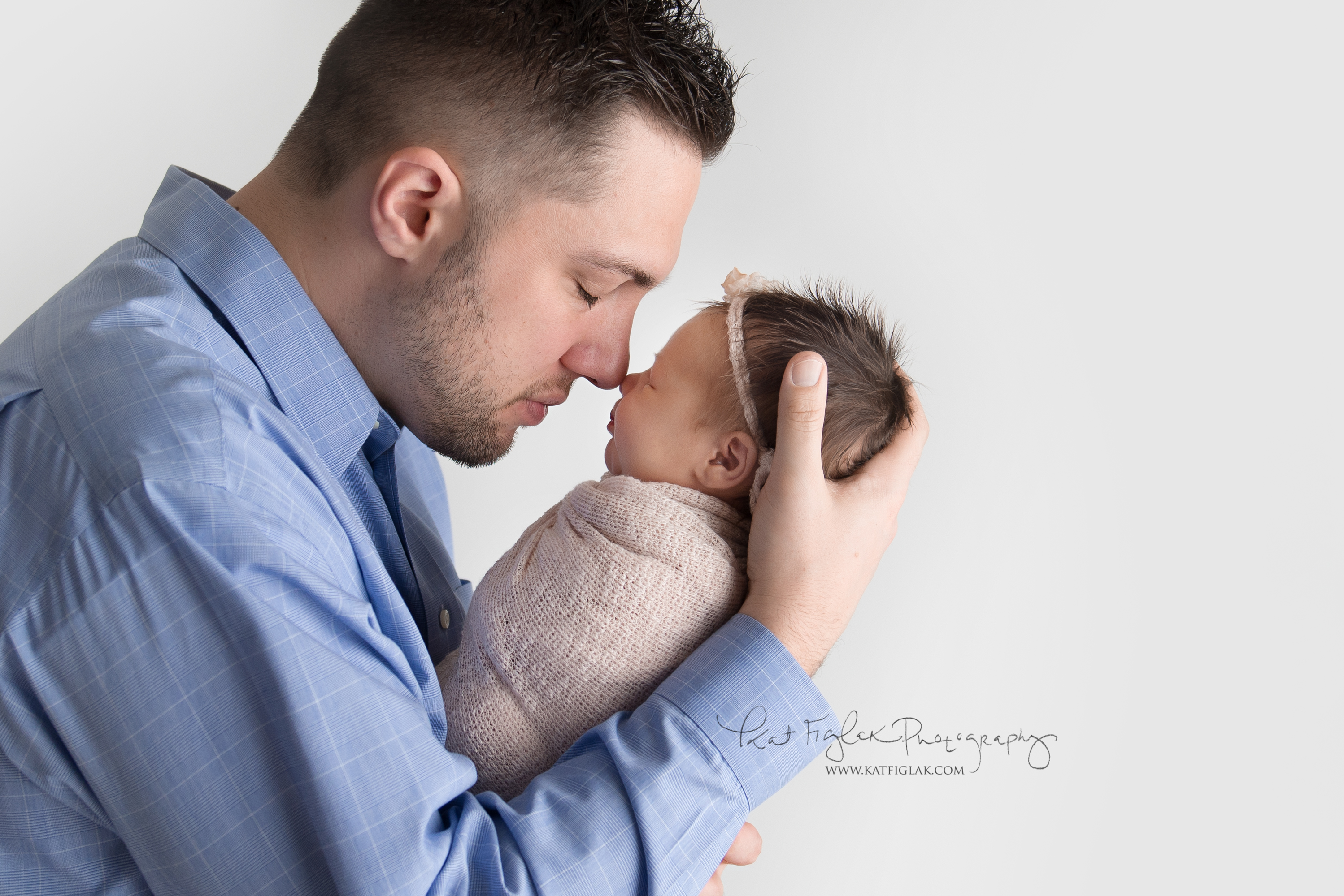 Dad holding baby girl nose to nose