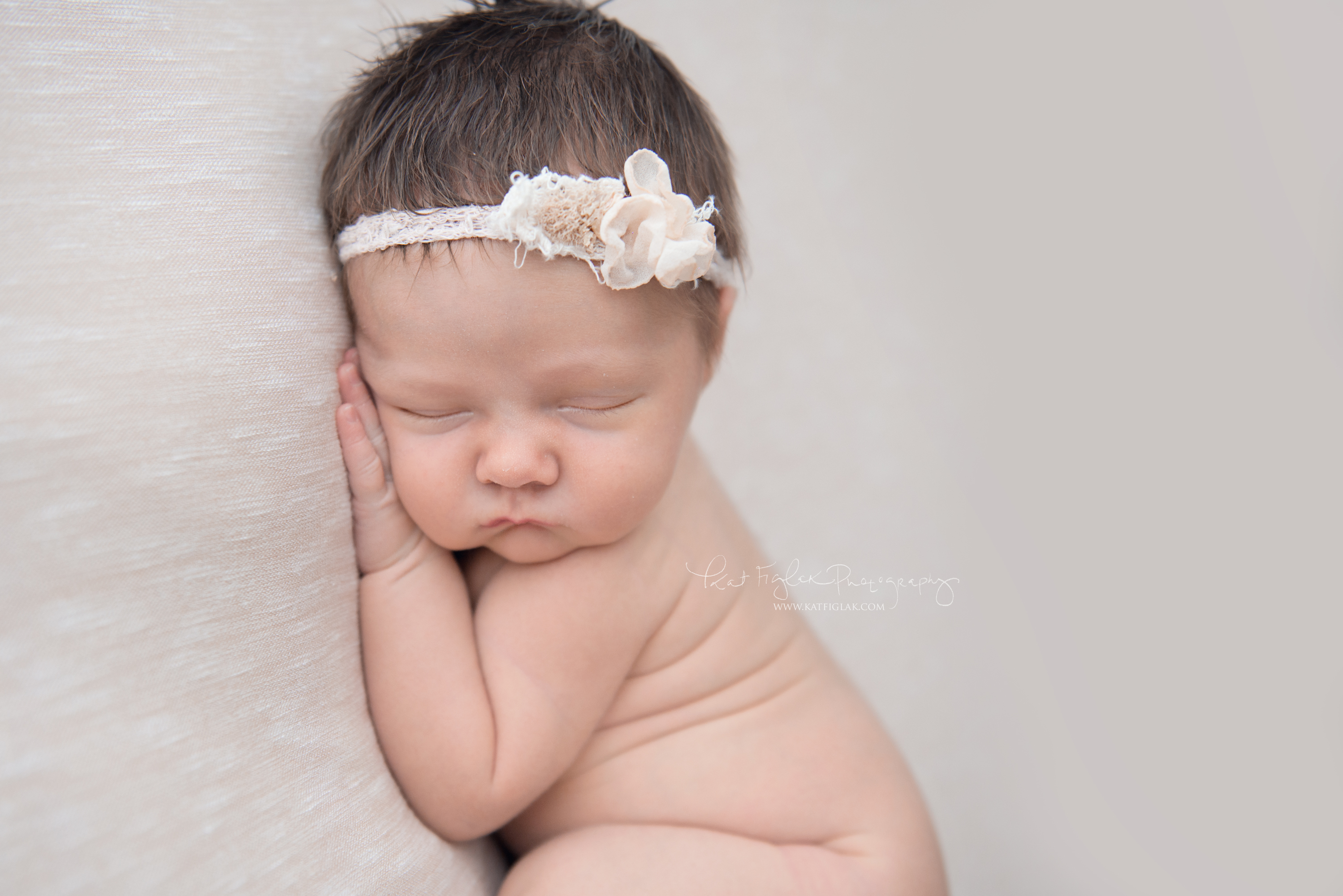 newborn baby girl sleeping wearing a floral headband