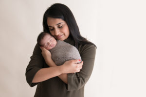 Mom holding her newborn baby boy wearing olive green
