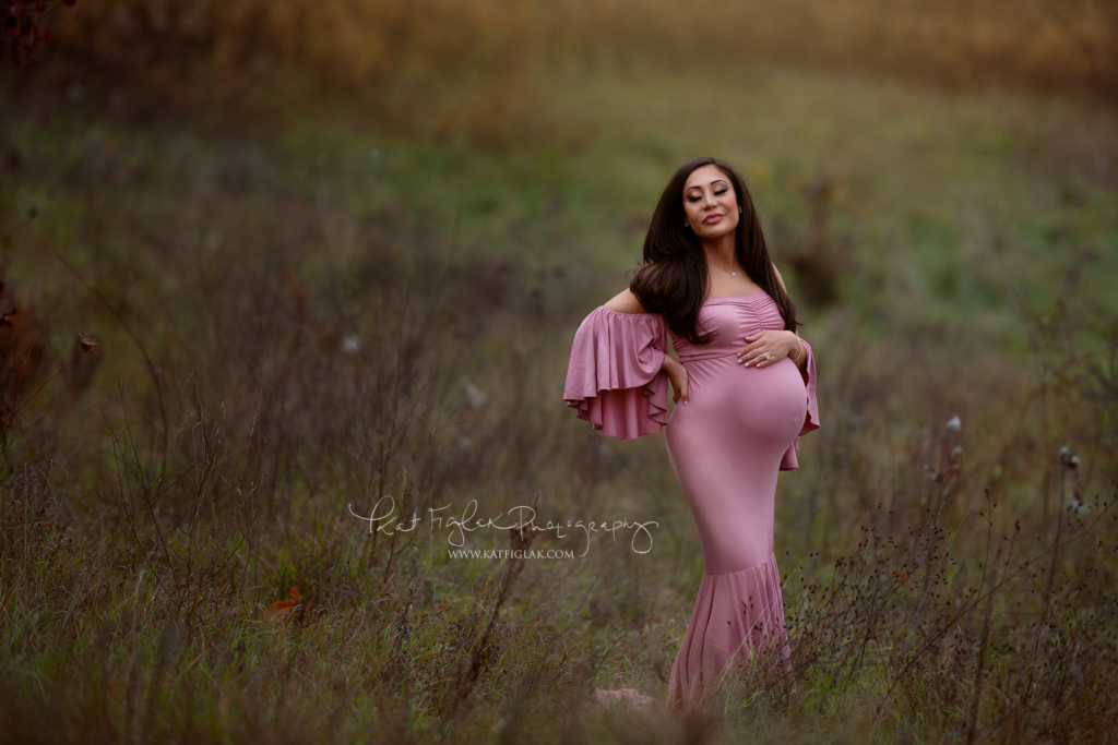 pregnant mom wearing a blush mii-estillo gown standing in a field