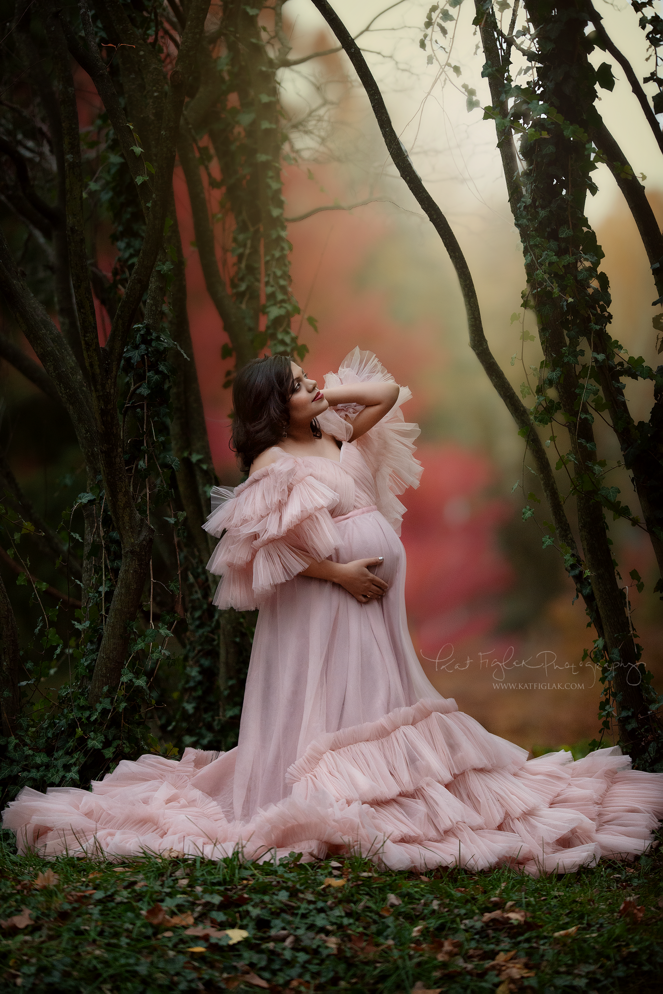 pregnant mom in pink tulle gown with pretty fall colors in the background