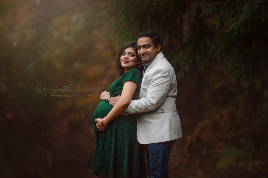 mom and husband expecting baby girl pregnant mom wearing an emerald gown