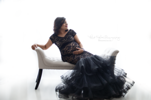 pregnant mom wearing a black lace gown from Mii-Estillo with a trumpet black skirt