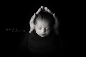picture of baby girl in her dads hands black and white