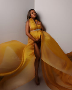 mom draped in flowing yellow fabric
