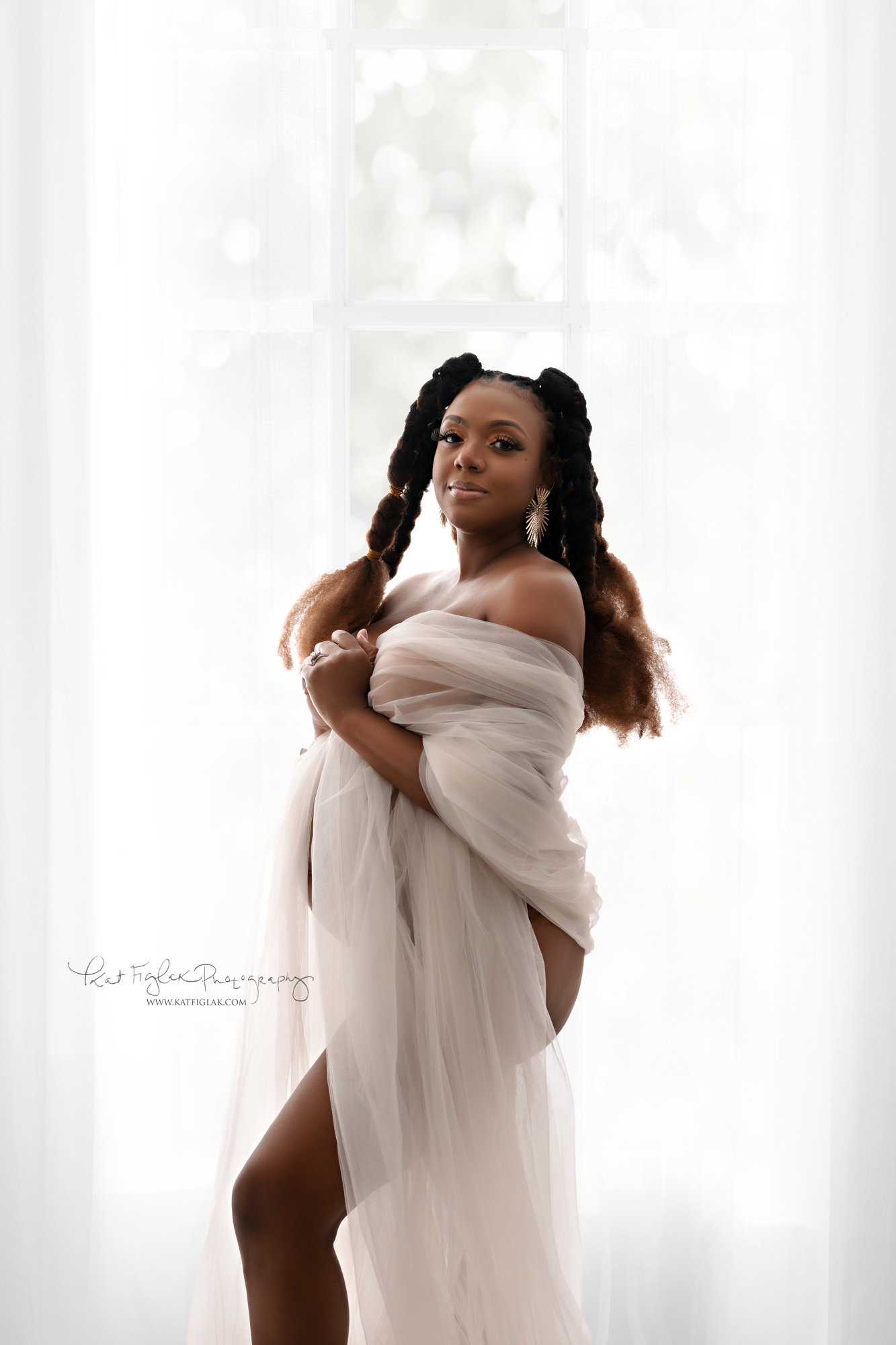 pregnant mom wrapped in white tulle fabric